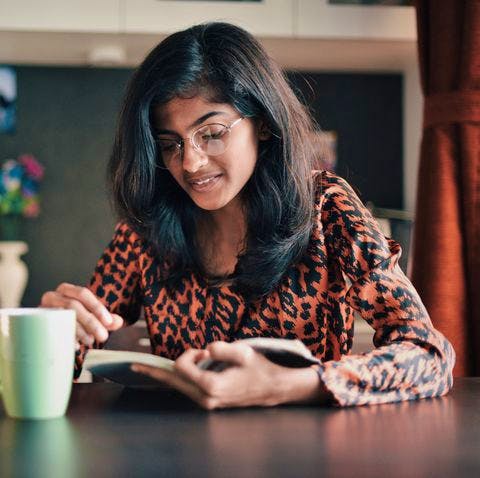 girl reading a book with a coffee mug- mental health during covid
